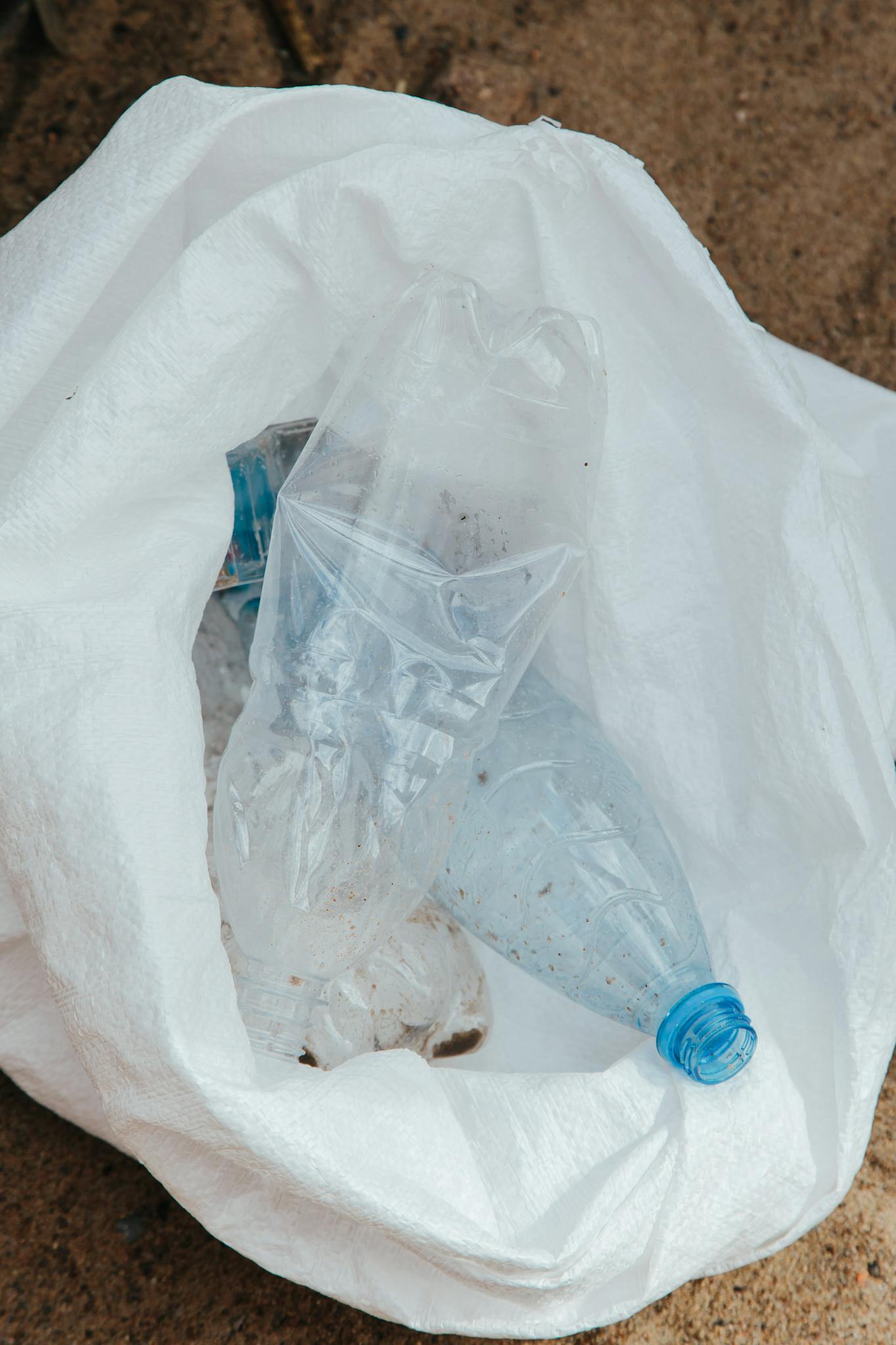 A collection of plastic waste in a white bag, highlighting environmental issues.